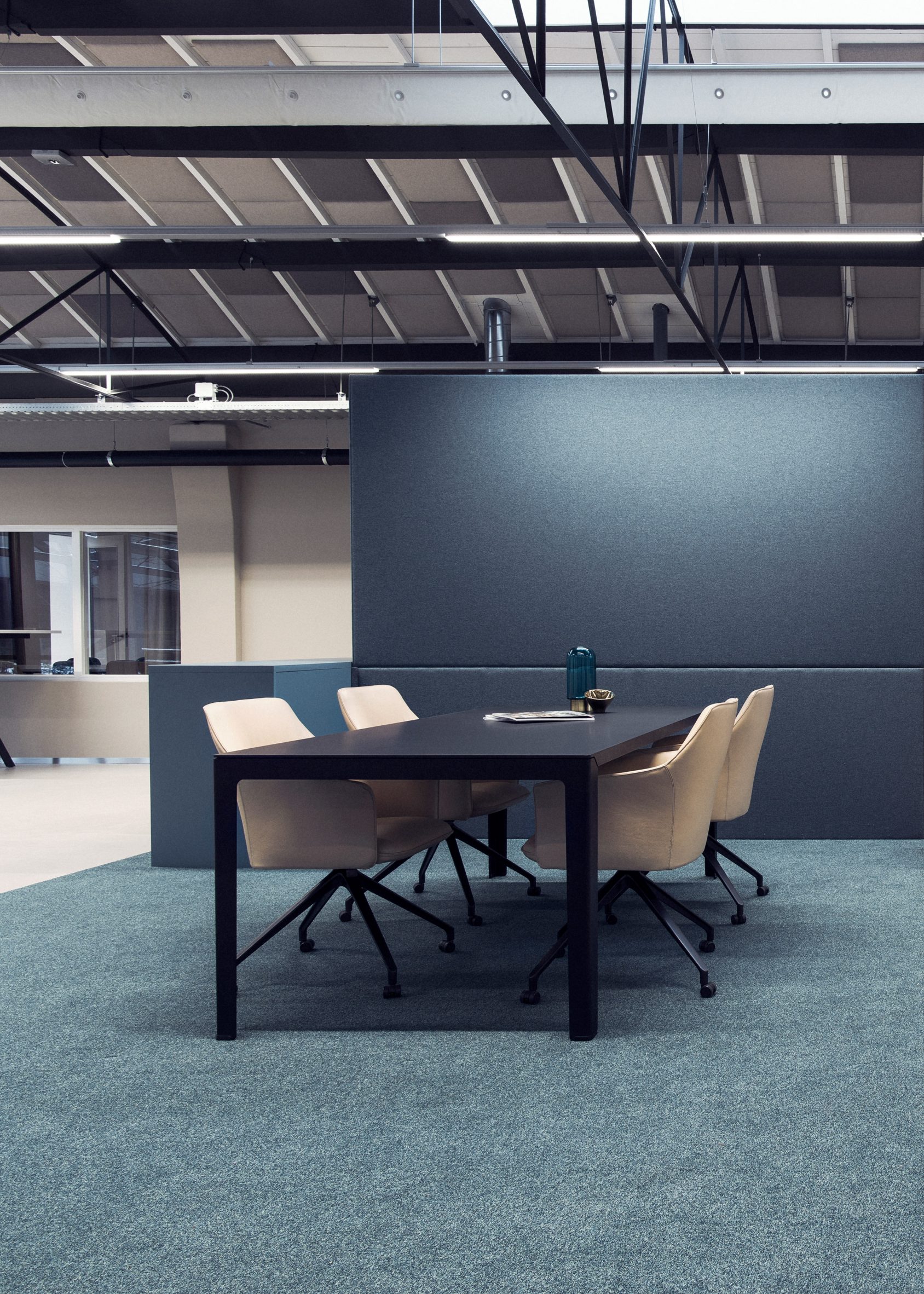 Four LXR671 armchairs in beige surrounding a black desk situated in an office setting