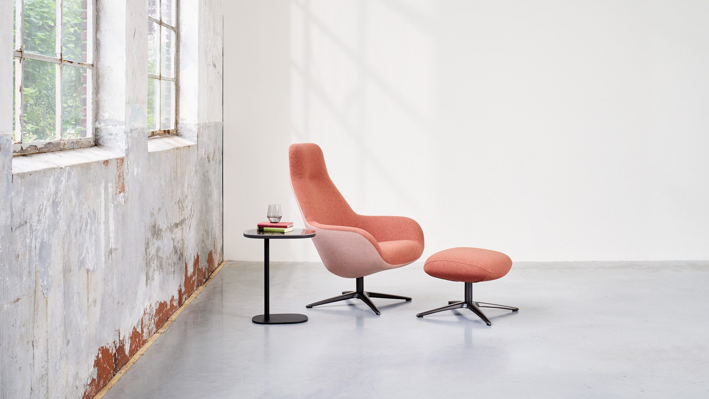 LXR03 armchair in blush pink finish with an accompanying footstool and side table situated in a pared-back room