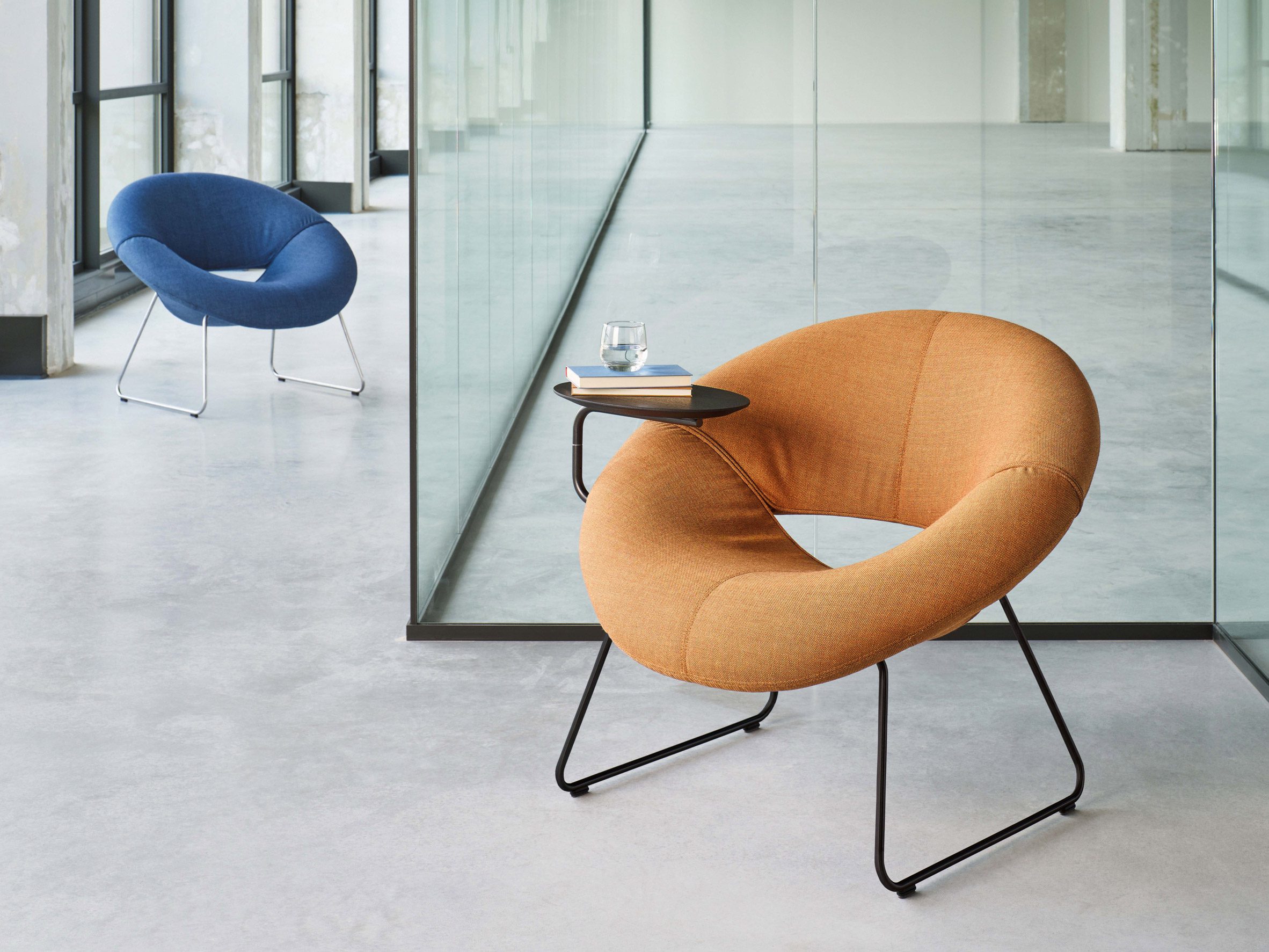 Orange LXR18 armchair with oak side table attached to its side holding books and water