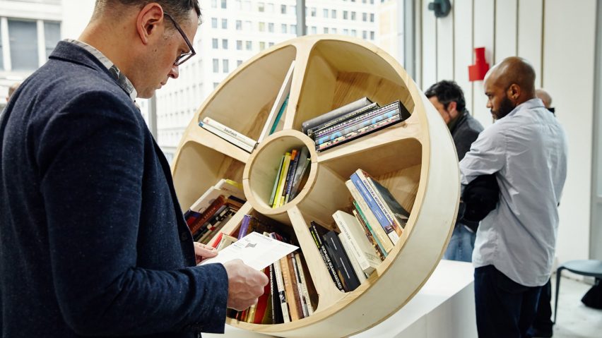 Человек смотрит на круглый книжный шкаф