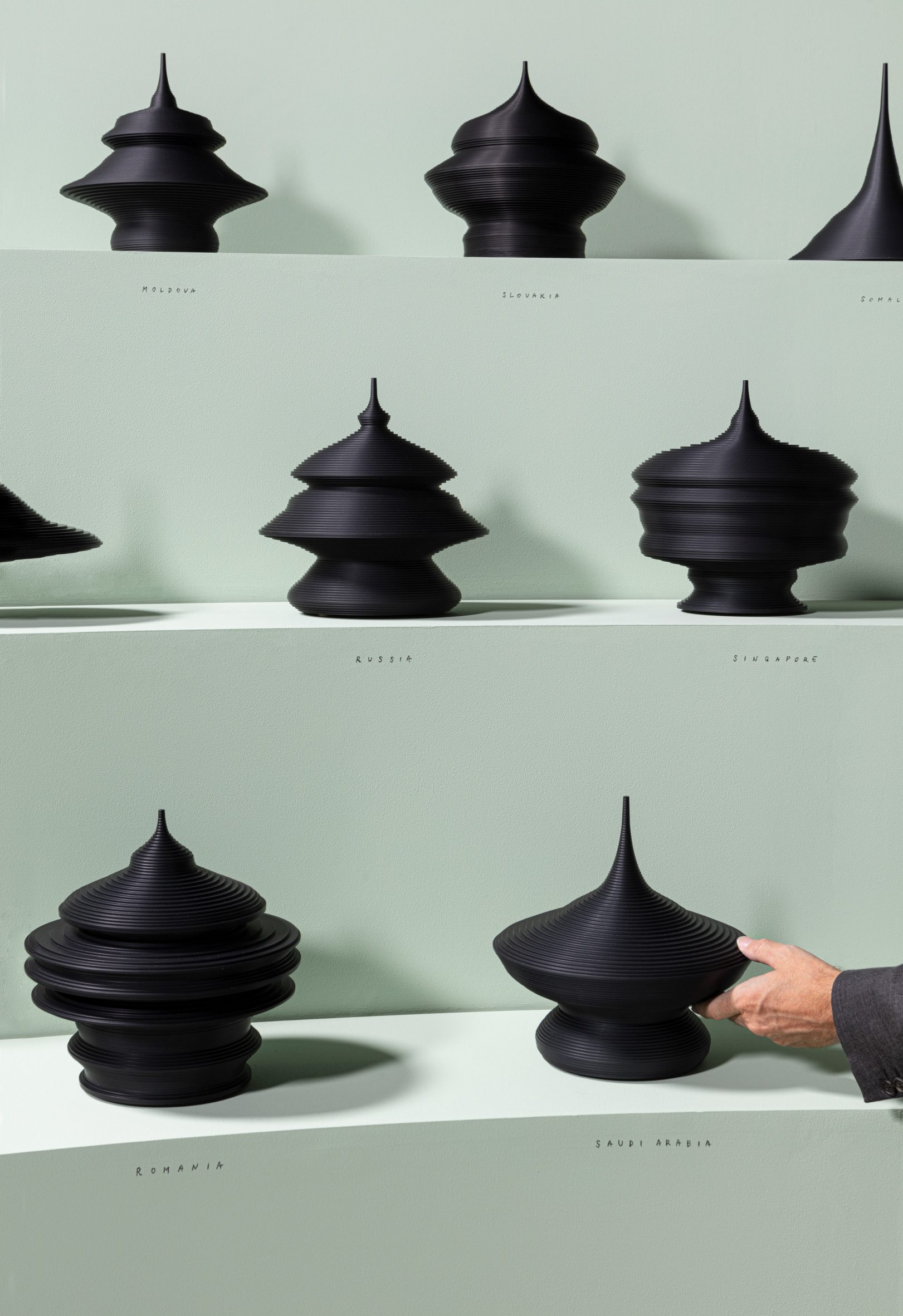 State of the World black sculptures on green shelves