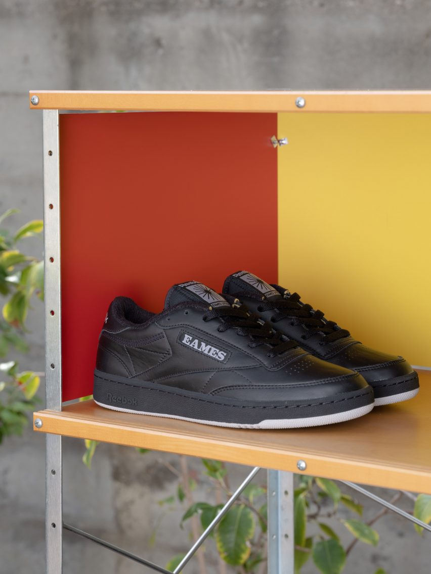 A pair of black Reebok trainers on a wooden shelf
