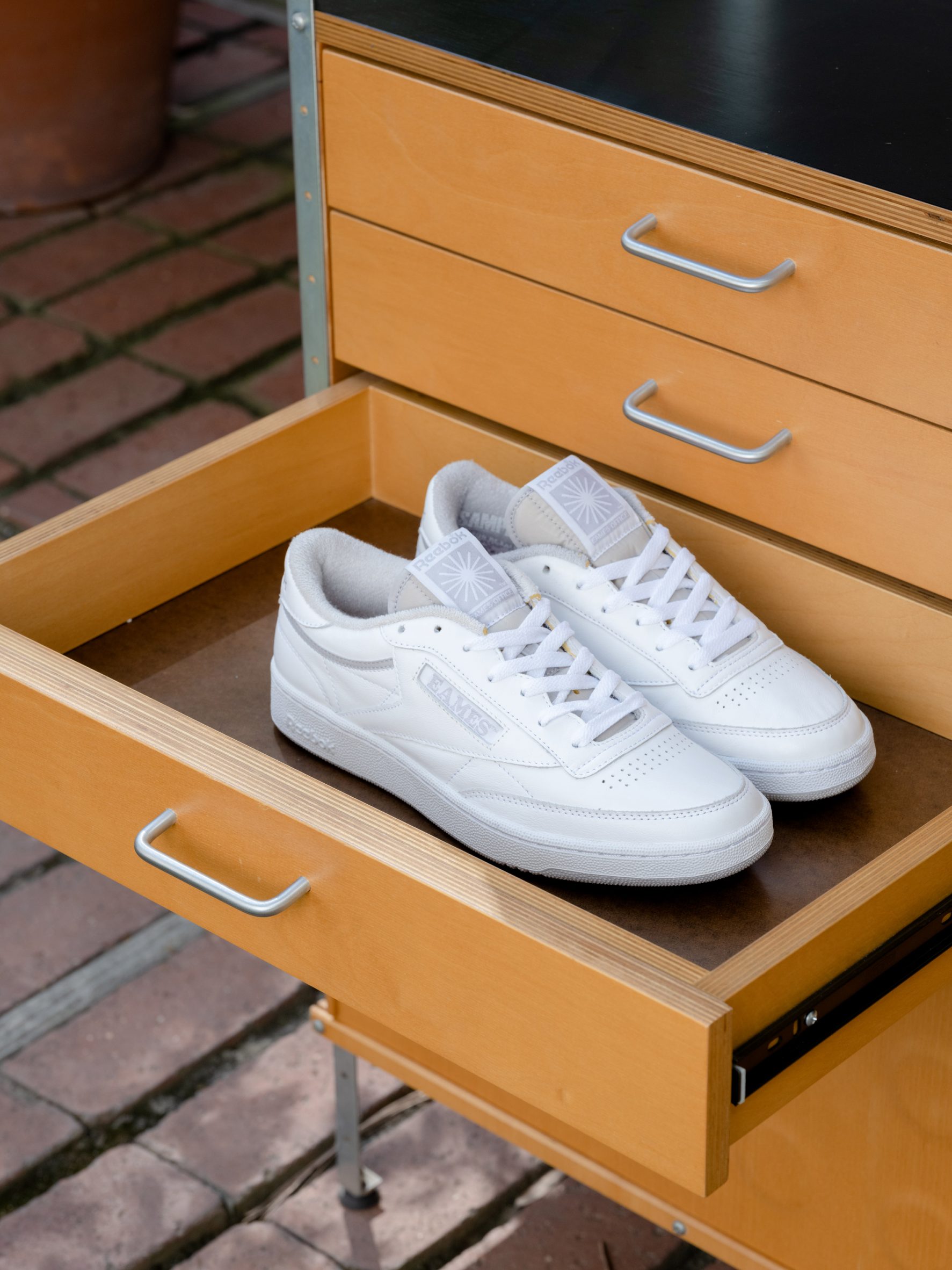 A pair of white Club C trainers in a drawer