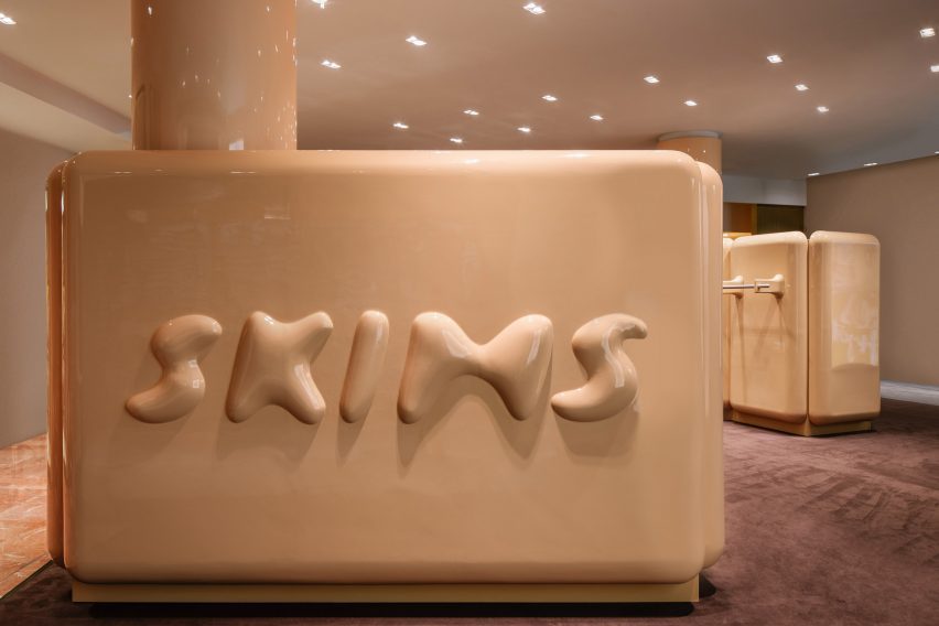 The SKIMS logo on a beige partition