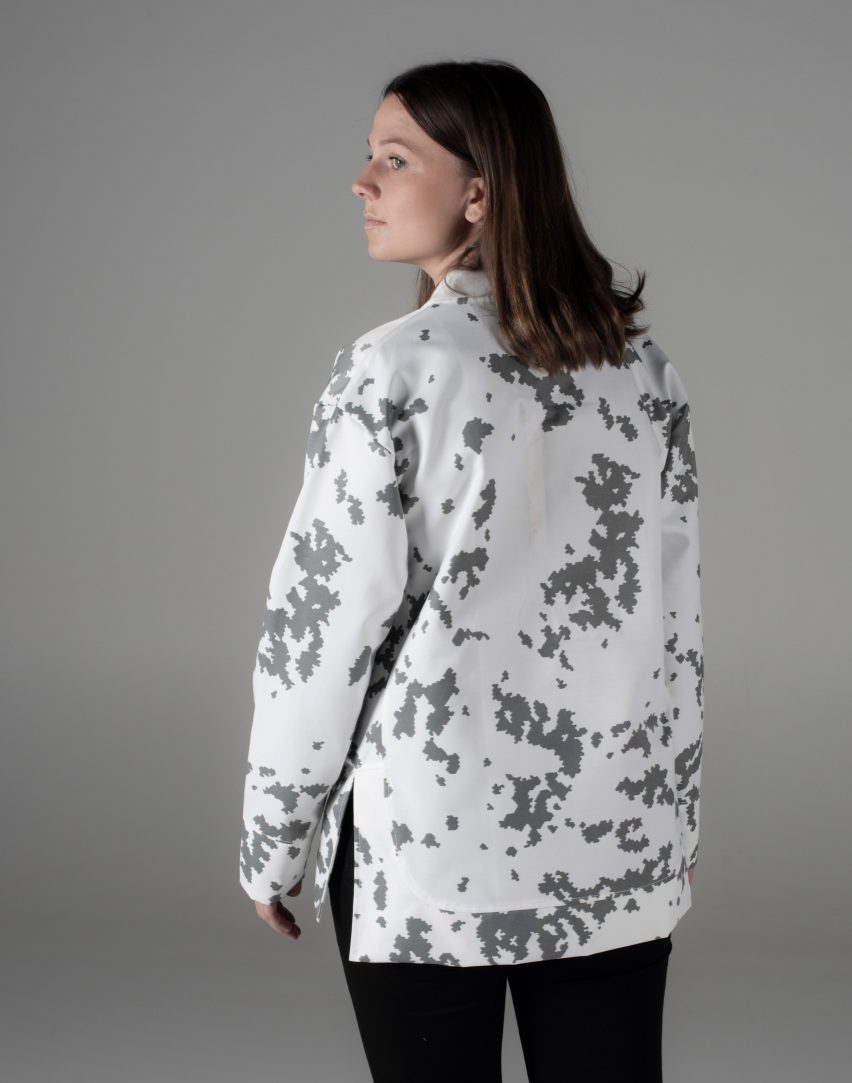 Woman wears a white solar-powered jacket with a grey graphic print