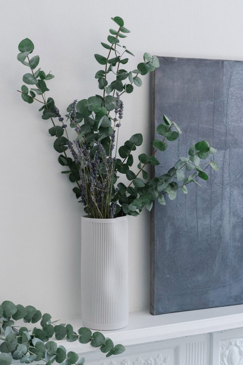 White Bora vase on a shelf holding eucalyptus leaves