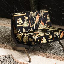 Two-seater black sofa upholstered in Dedar's This Must Be The Place fabric with golden embroidered birds and plants