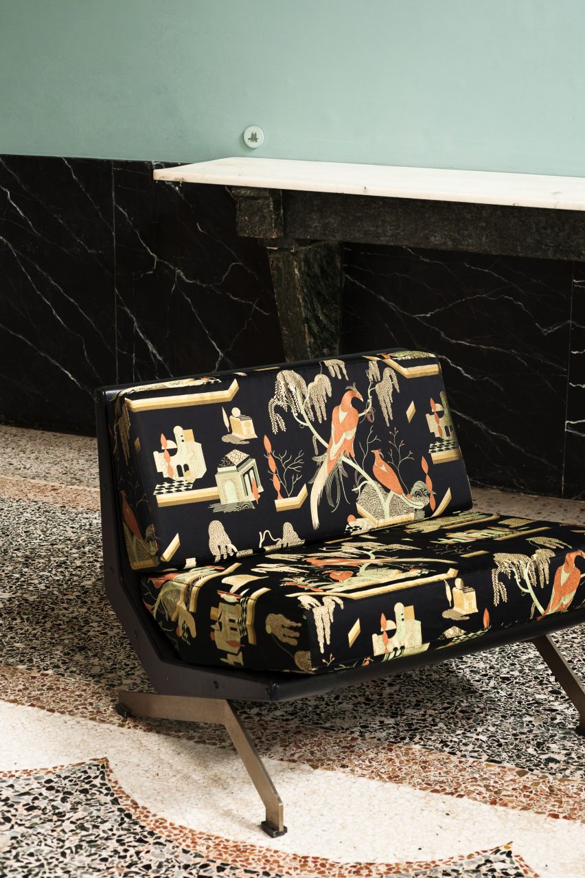 Two-seater black sofa upholstered in This Must Be The Place fabric, which has golden embroidered birds and plants