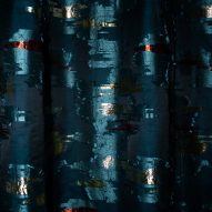 Close up of Dedar's Dalie Papaveri Tulipani fabric in dark blue with flecks of metallic gold and red