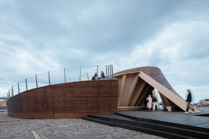 People walking through the triangular entrance to Verstas Architects' pavilion on Helsinki's South Harbour