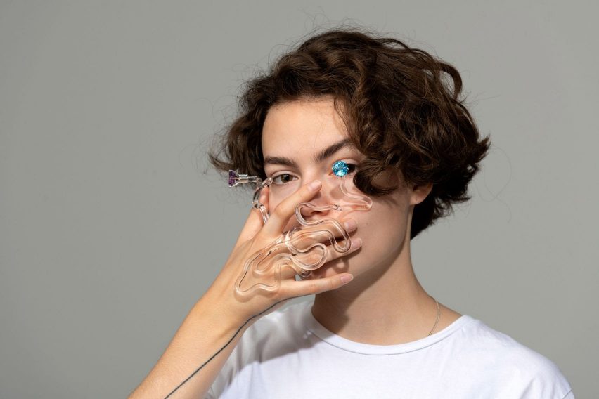 Person holding a piece of glass jewellery in front of their face