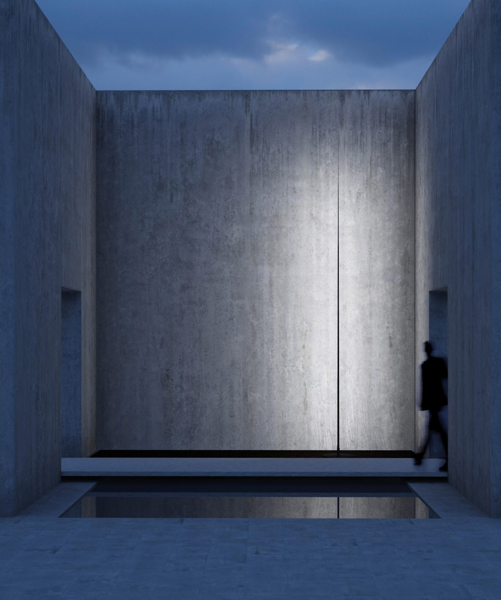 A photograph of the narrow matte black Origine light illuminating a concrete building