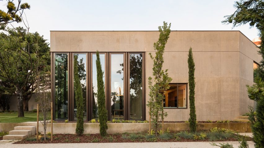 Casa 2 Porto exterior view showing concrete facade, double-height doors and tall planting