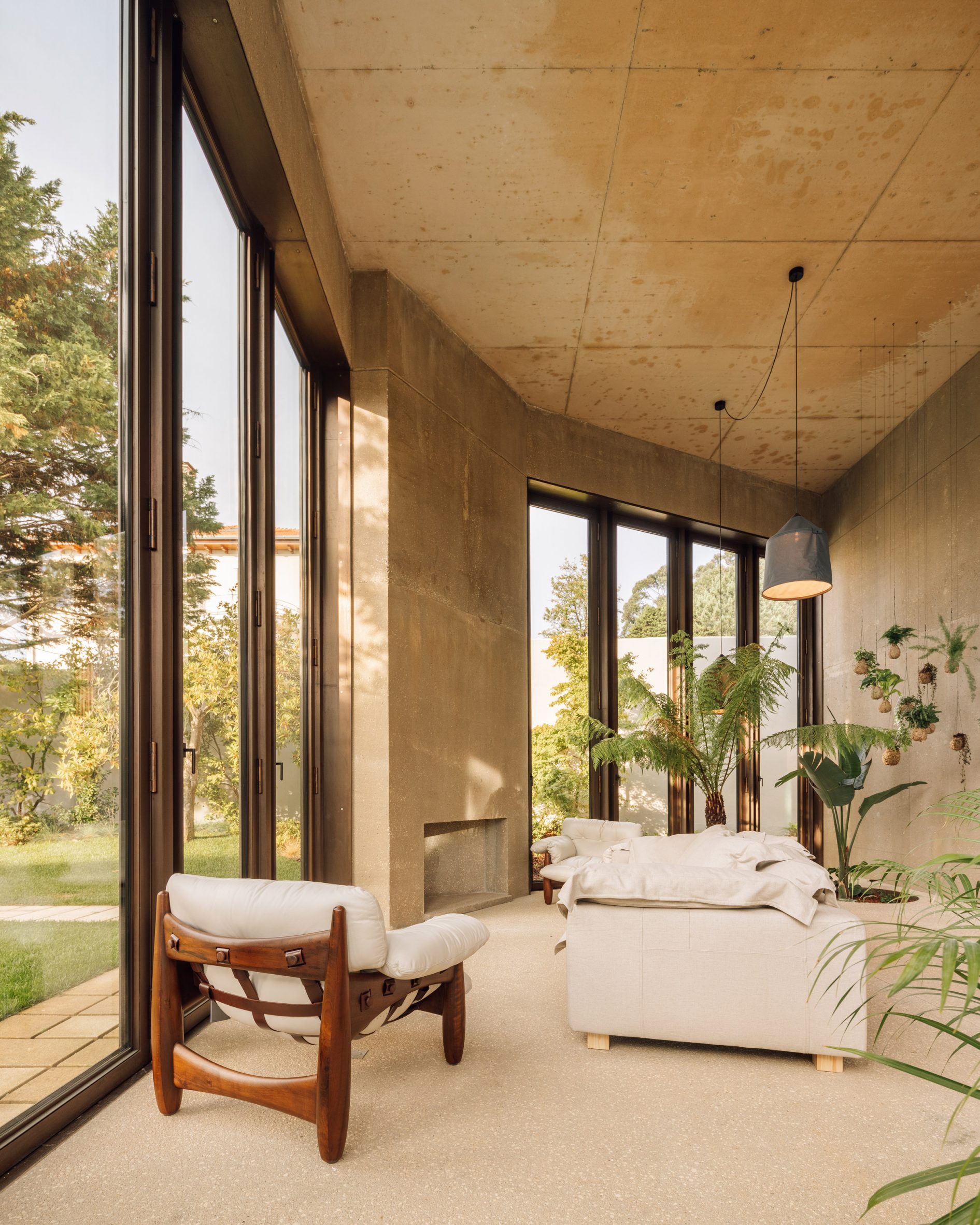 Living room of Casa 2 Porto by Bak Gordon Arquitectos with concrete walls and beige soft furnishings