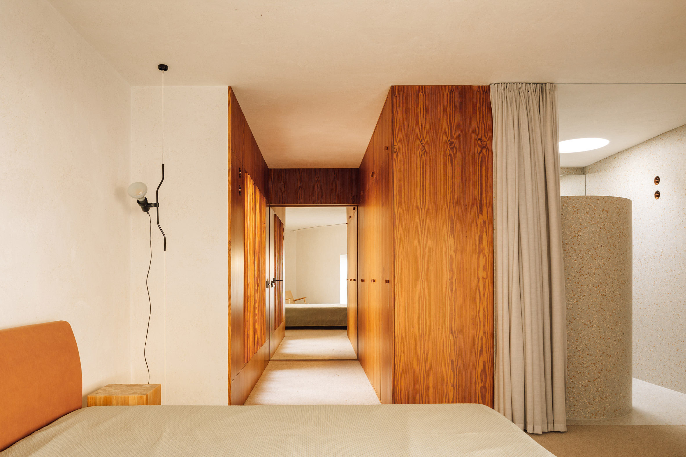 Interior view of a bedroom in garden annexe by Bak Gordon Arquitectos with built-in wooden wardrobes