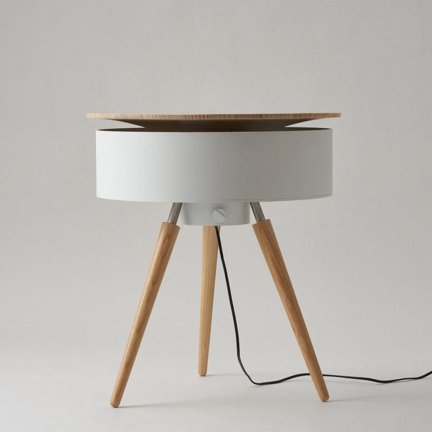 Meja samping bundar putih dengan bagian atas kayu membentuk bentuk kerucut terbalik di mana ia bertemu dengan meja