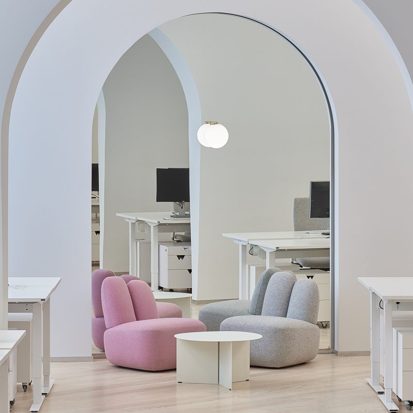Two Bunny lounge chairs in pink and grey situated within an office-like interior