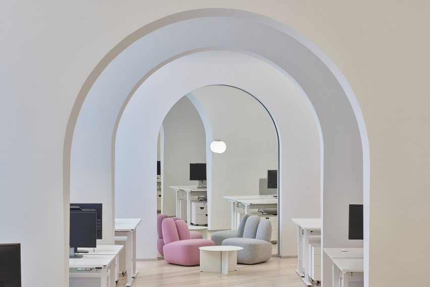 A photograph of two Bunny lounge chairs in pink and grey situated within an office-like interior