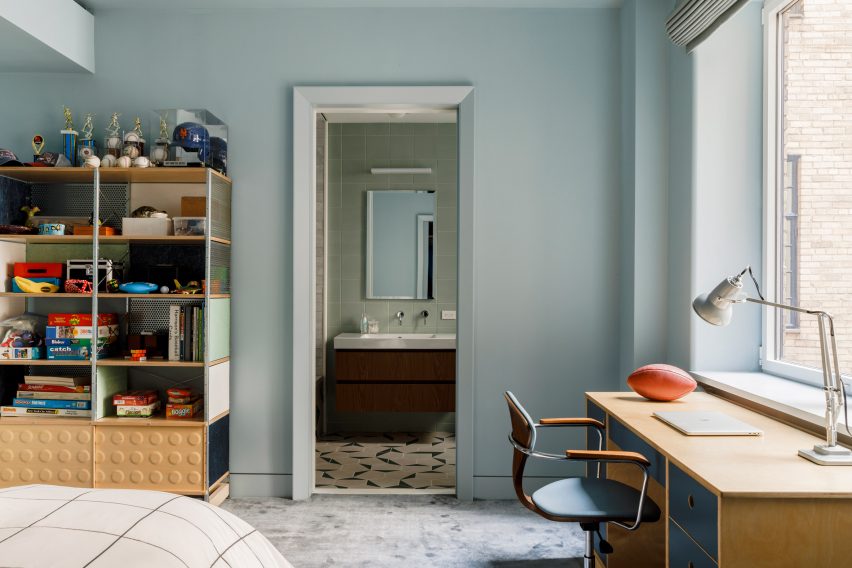 A blue children's bedroom leading to a bathroom