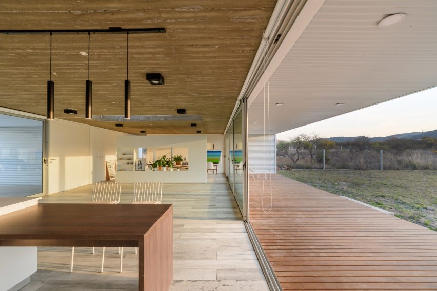 An open plan kitchen and living room overlooking green grass