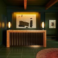 Reception desk with black corrugated base in dark green lobby of Chief Chicago by AvroKO