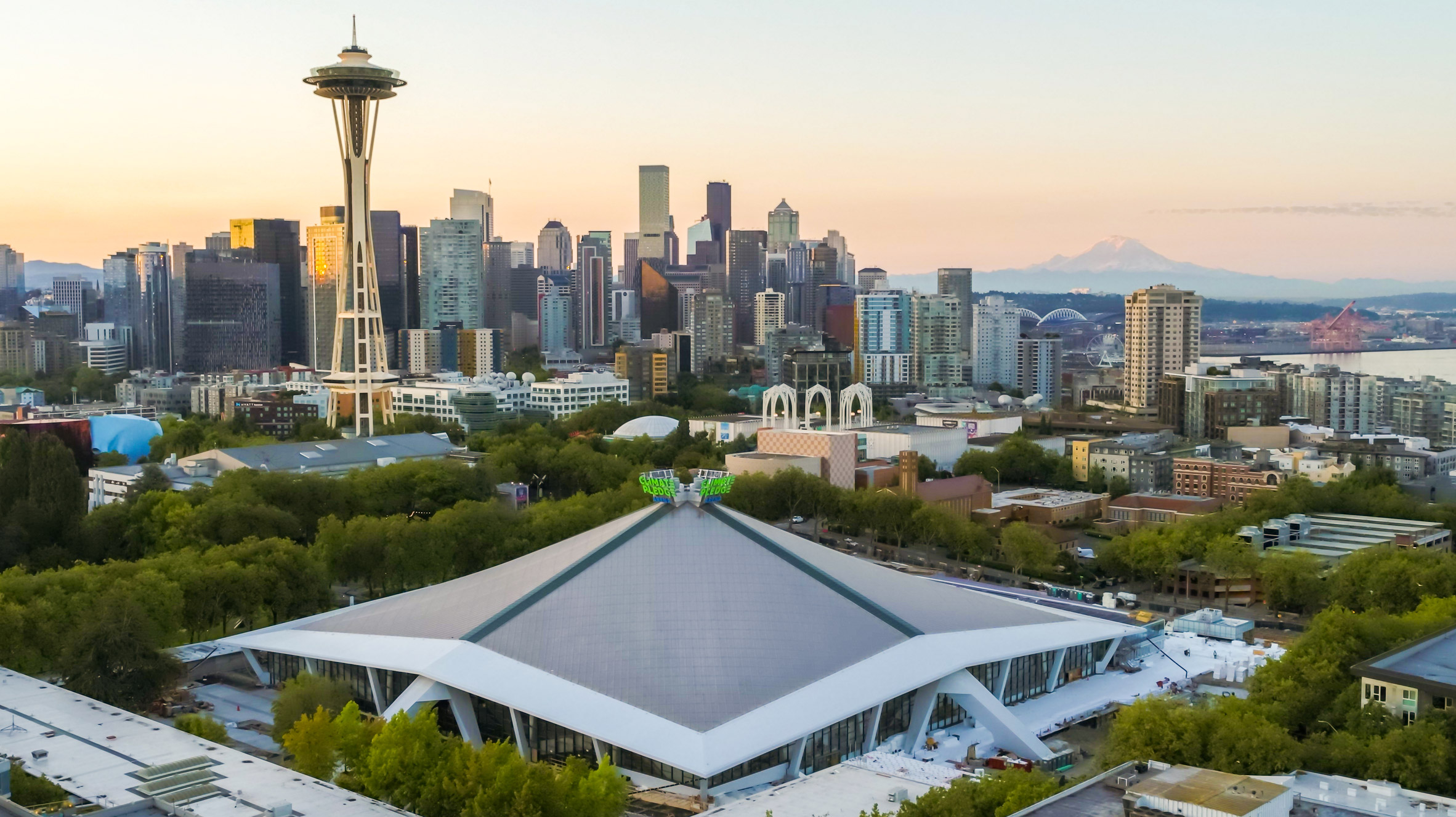Exterior view of the Climate Pledge Arena against the Seattle skyline