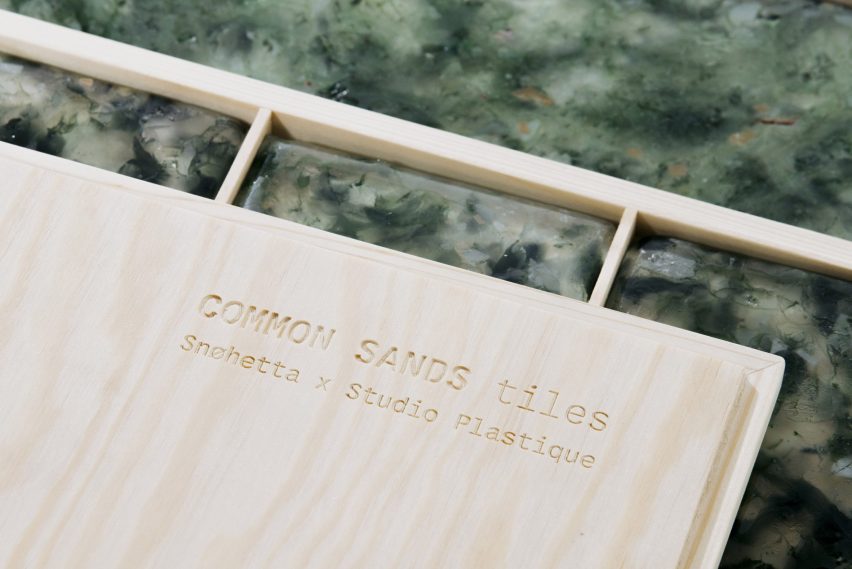 Green speckled glass tiles in wood packaging branded with the words 'Common Sands tiles Snohetta x Studio Plastique'