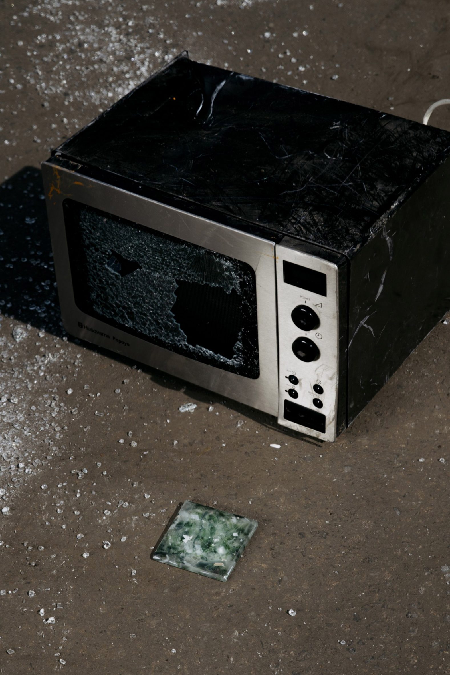Microwave with shattered glass next to a Forite tile