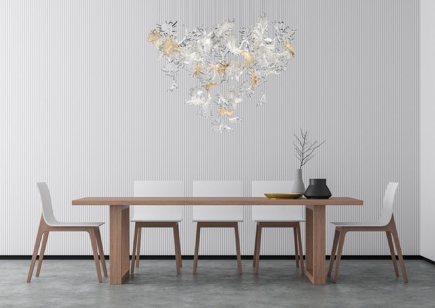 Lasvit's Dancing Leaves glass lighting sculpture in light amber and clear suspended above a dining table