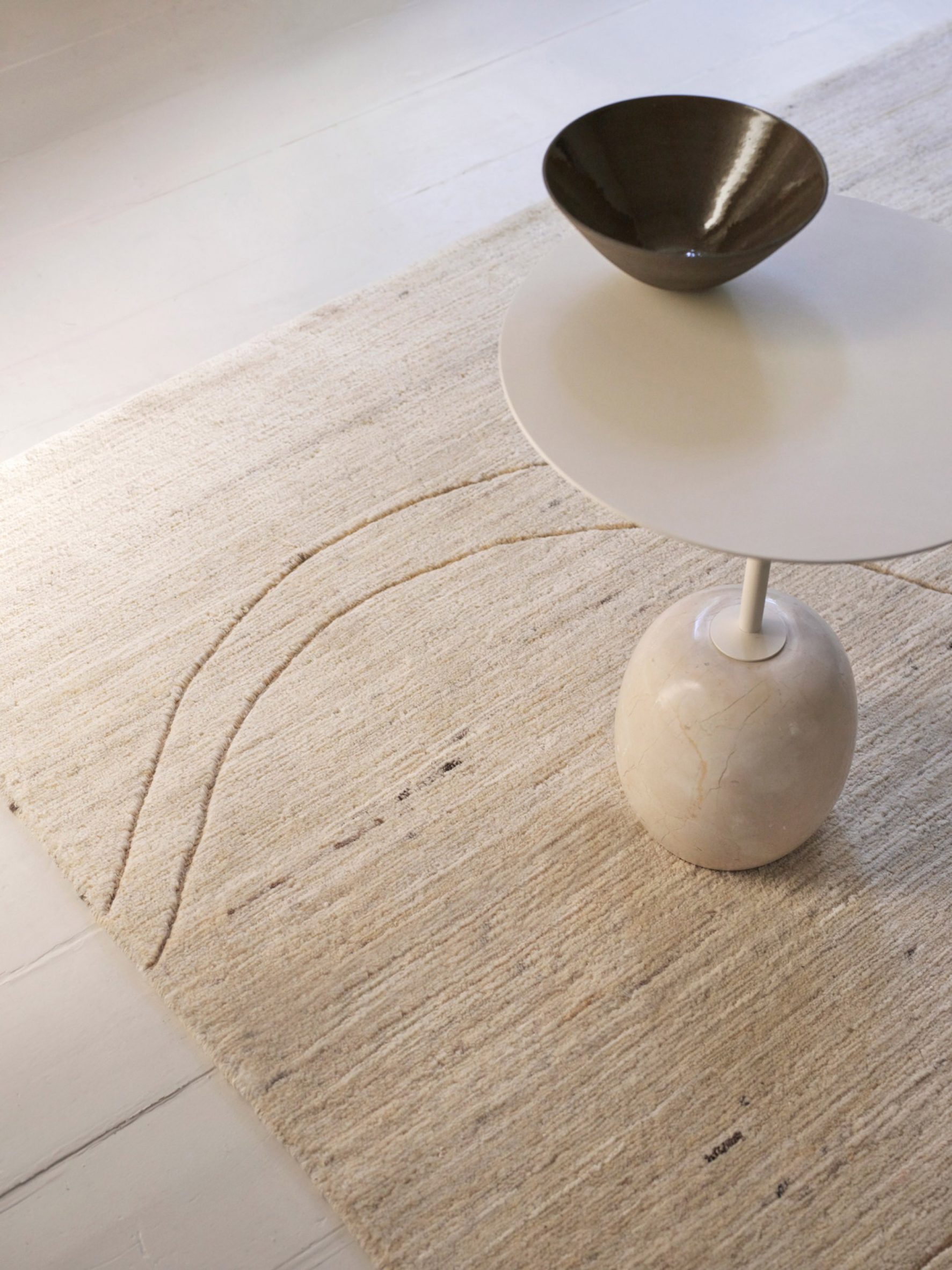 A cream rug and table from the Ellipse Collection