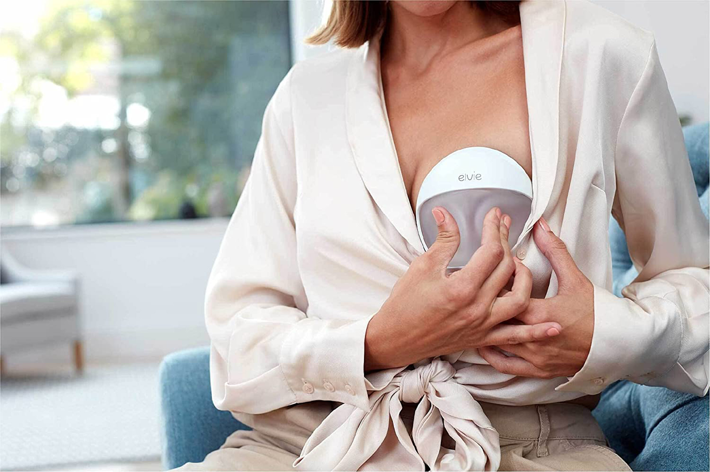 Women squeezing Elvie Curve breast pump to create vaccuum