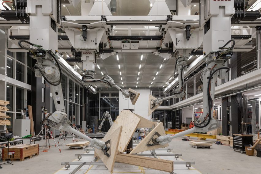 Lengan robot bergerak di udara memegang panel kayu di pusat manufaktur