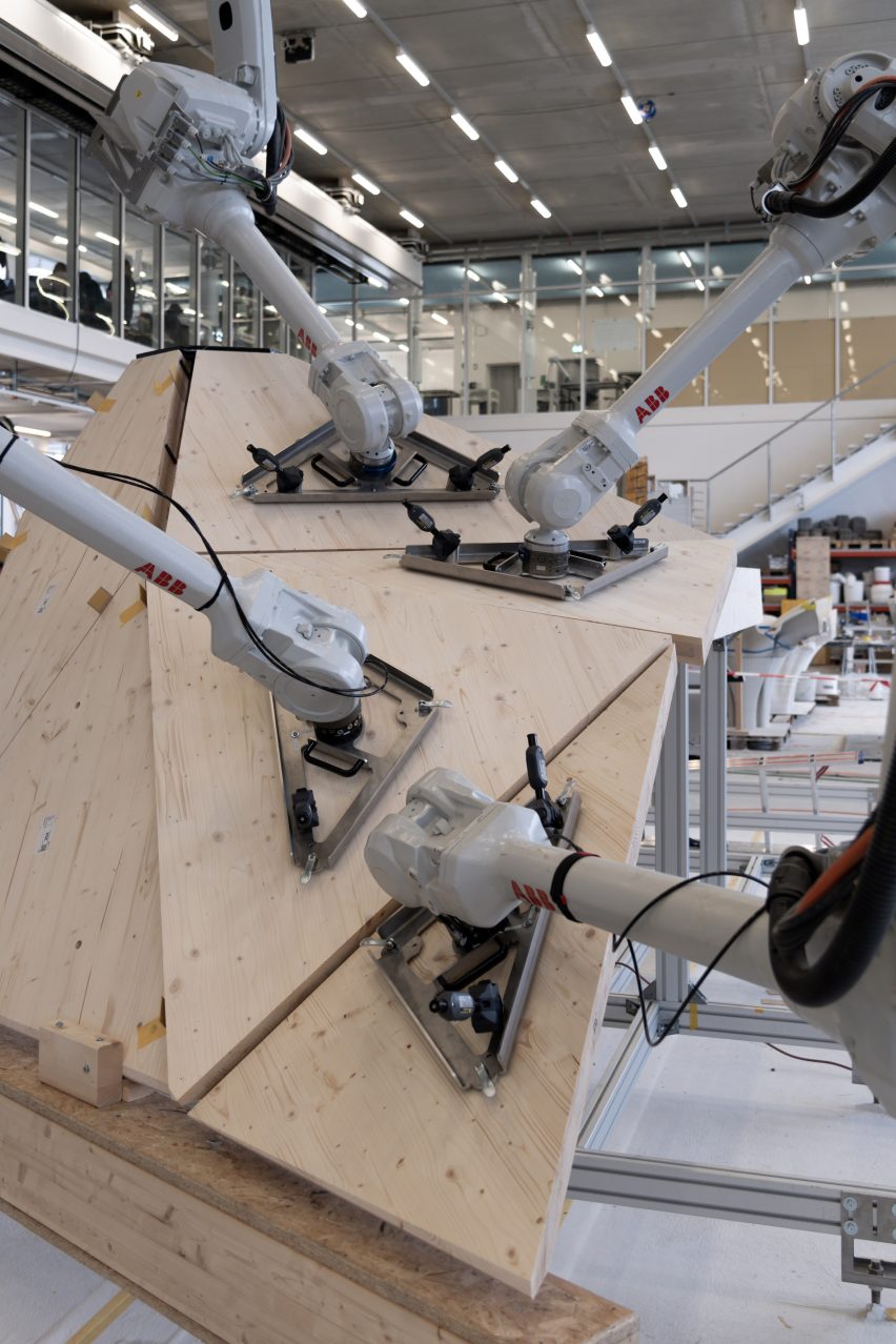 ETH Zurich robots hold several geometrically shaped wooden panels in place like a jigsaw