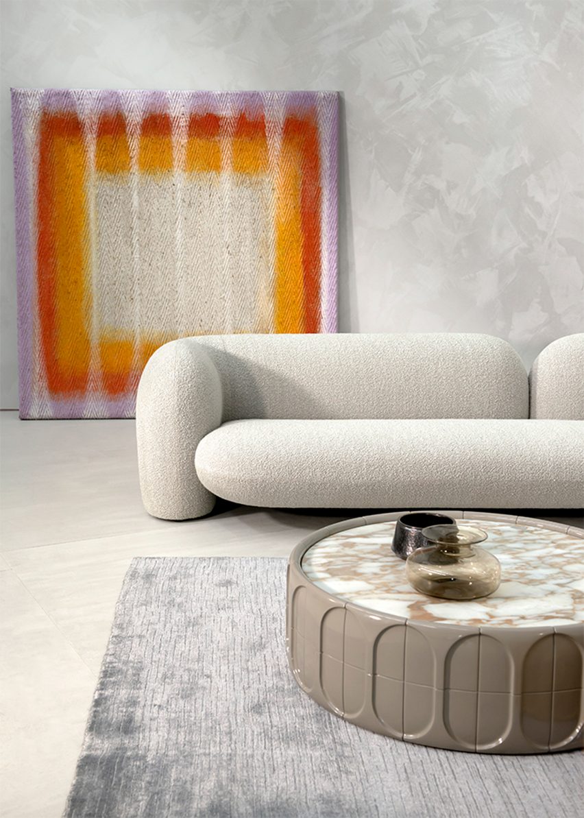 Image of the Gio sofa in a room with a rainbow artwork behind it
