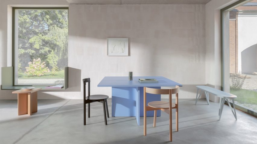 A photograph of Jazz dining chairs around a blue table in a naturally lit room