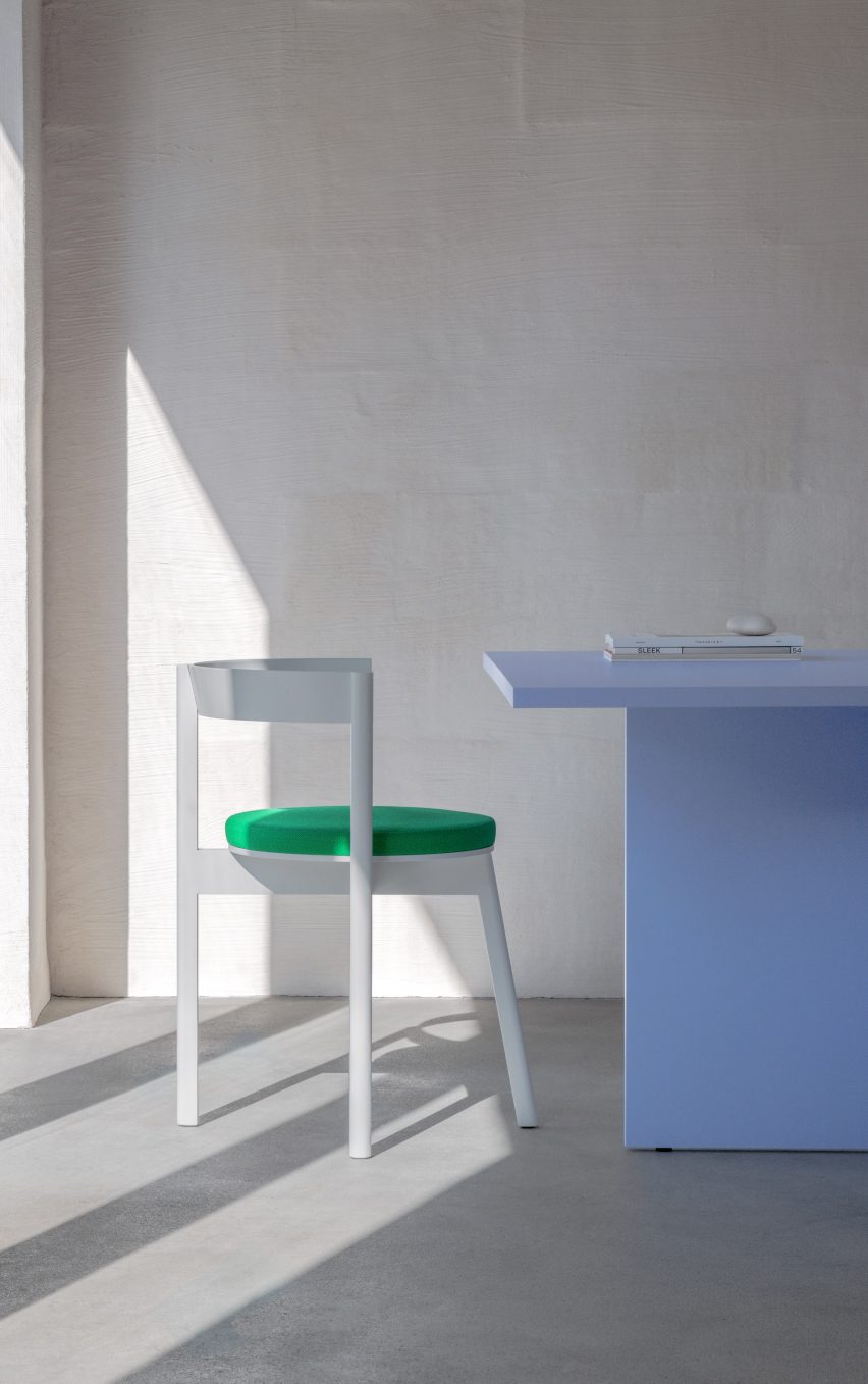 White Jazz dining chair with green cushion in front of blue table