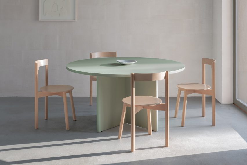 木制餐椅由David和Julian Löhr为Loehr设计，周围是绿色的圆形餐桌