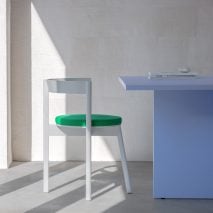 White and green Jazz dining chair by David and Julian Löhr for Loehr in front of a blue table