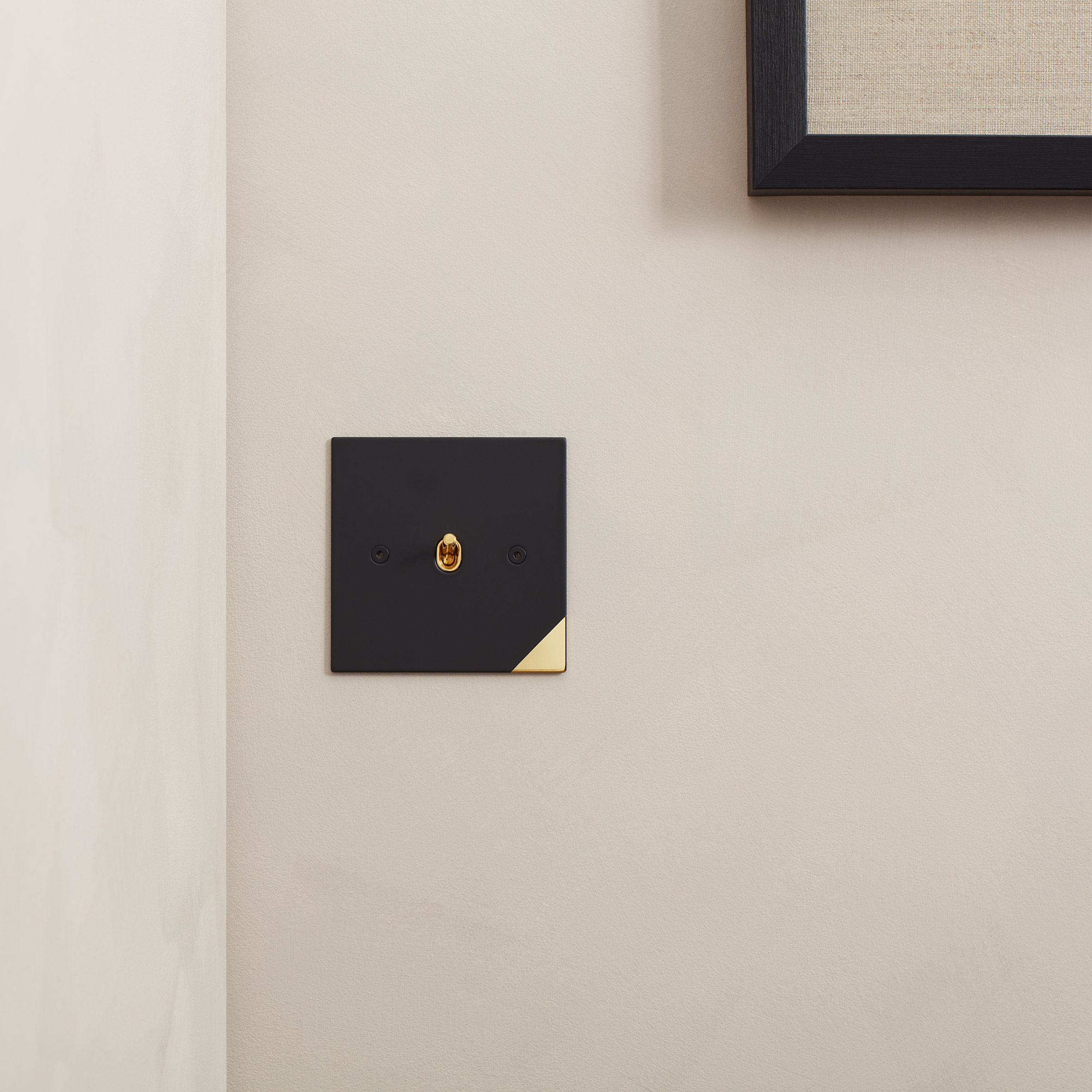 Black light switch with gold corner detail by Kelly Hoppen 