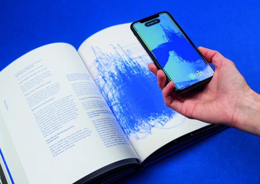 Hand holding a smartphone over a page of the Stories in Sounds publication