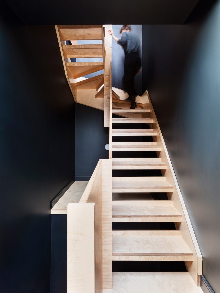 Dark blue stairwell with a wooden stairs 