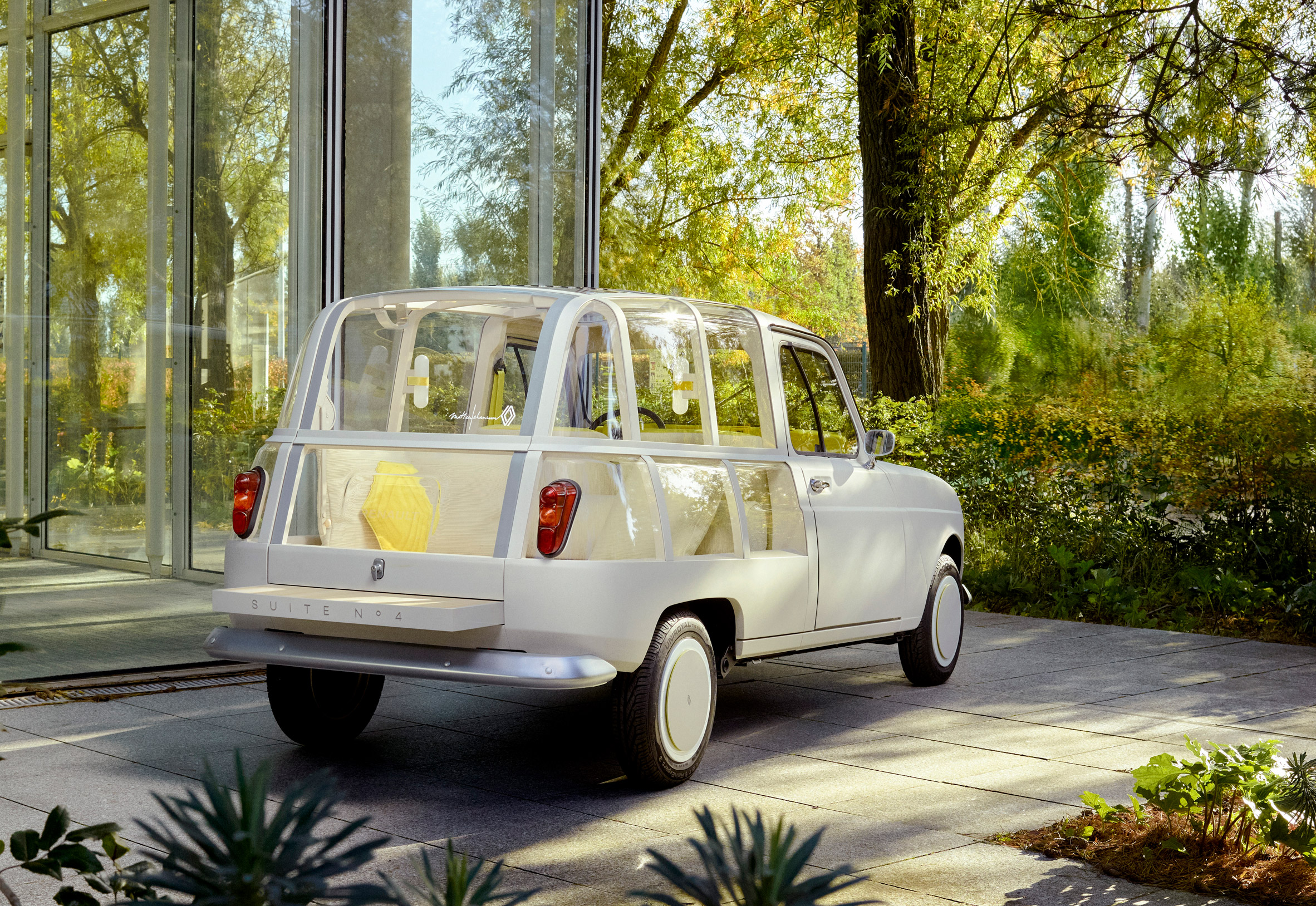 Renault 4L with cream and transparent body parked in a forest setting