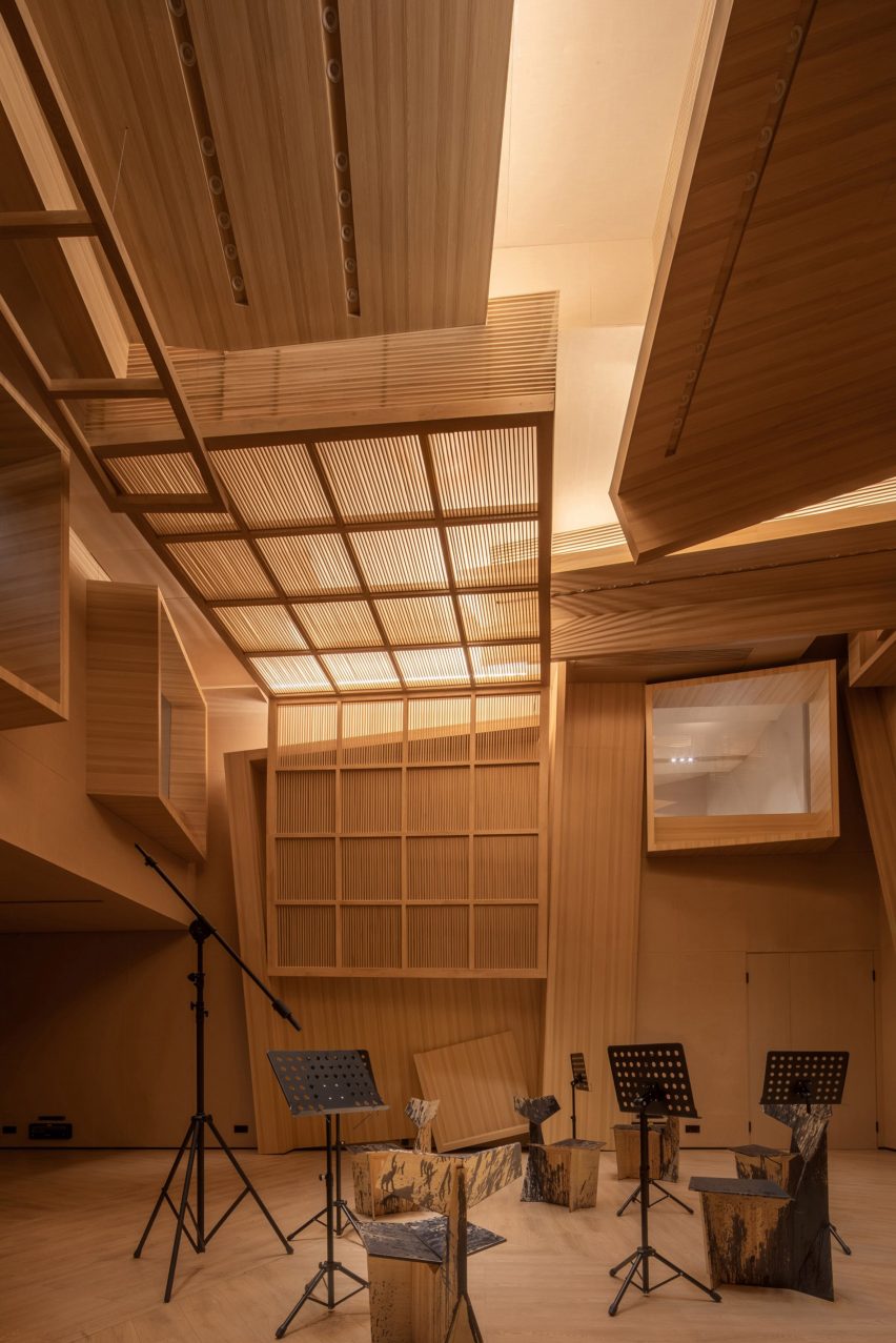 Interior kayu Meilan Music Studio dengan stand musik hitam di dalamnya