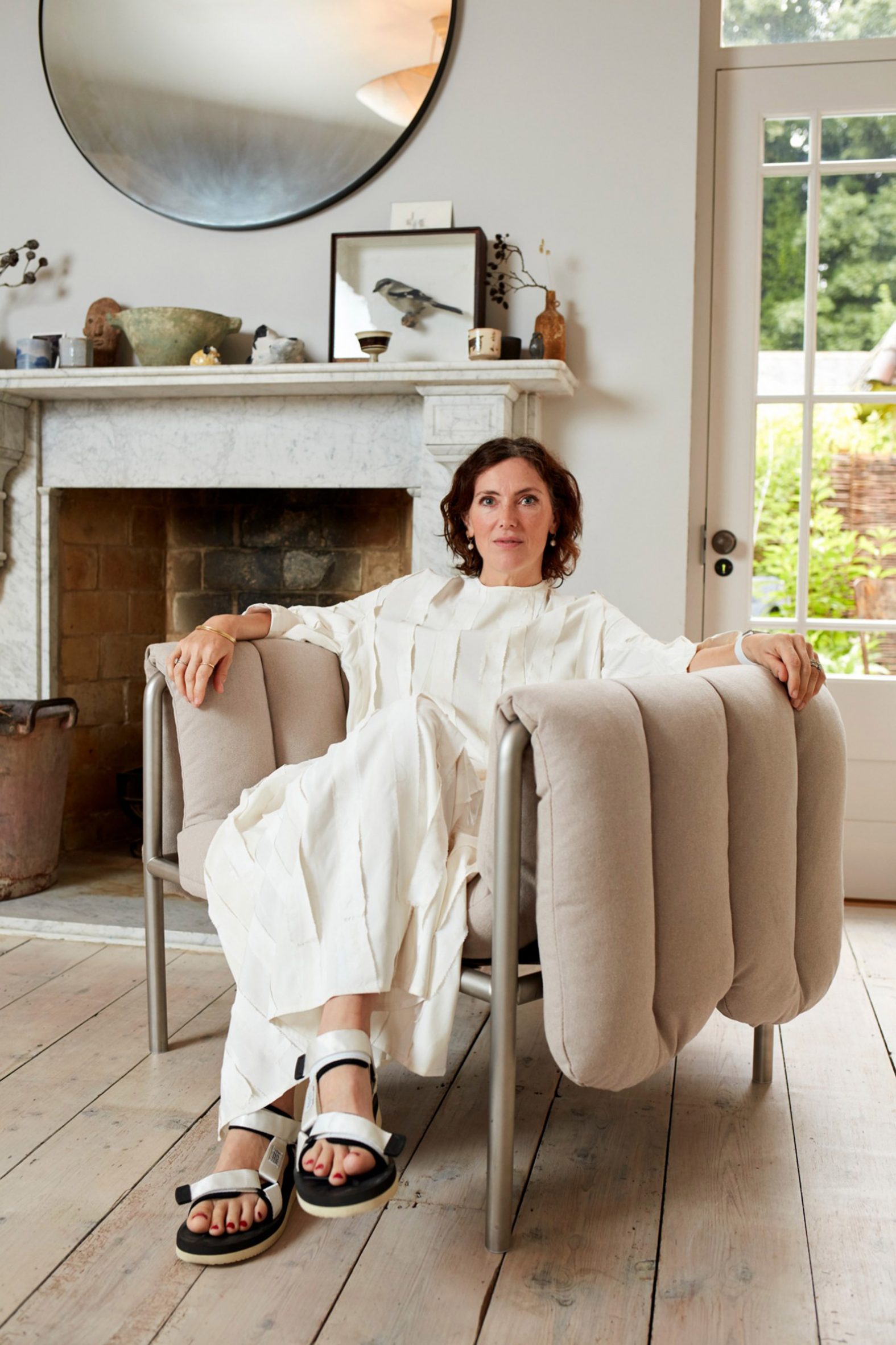 Faye Toogood sitting in a Puffy Lounge Chair with beige linen upholstery