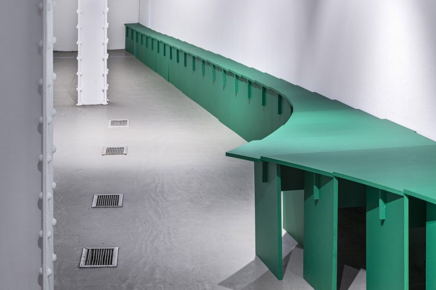 A curving series of green tables in the Storefront for Art and Architecture