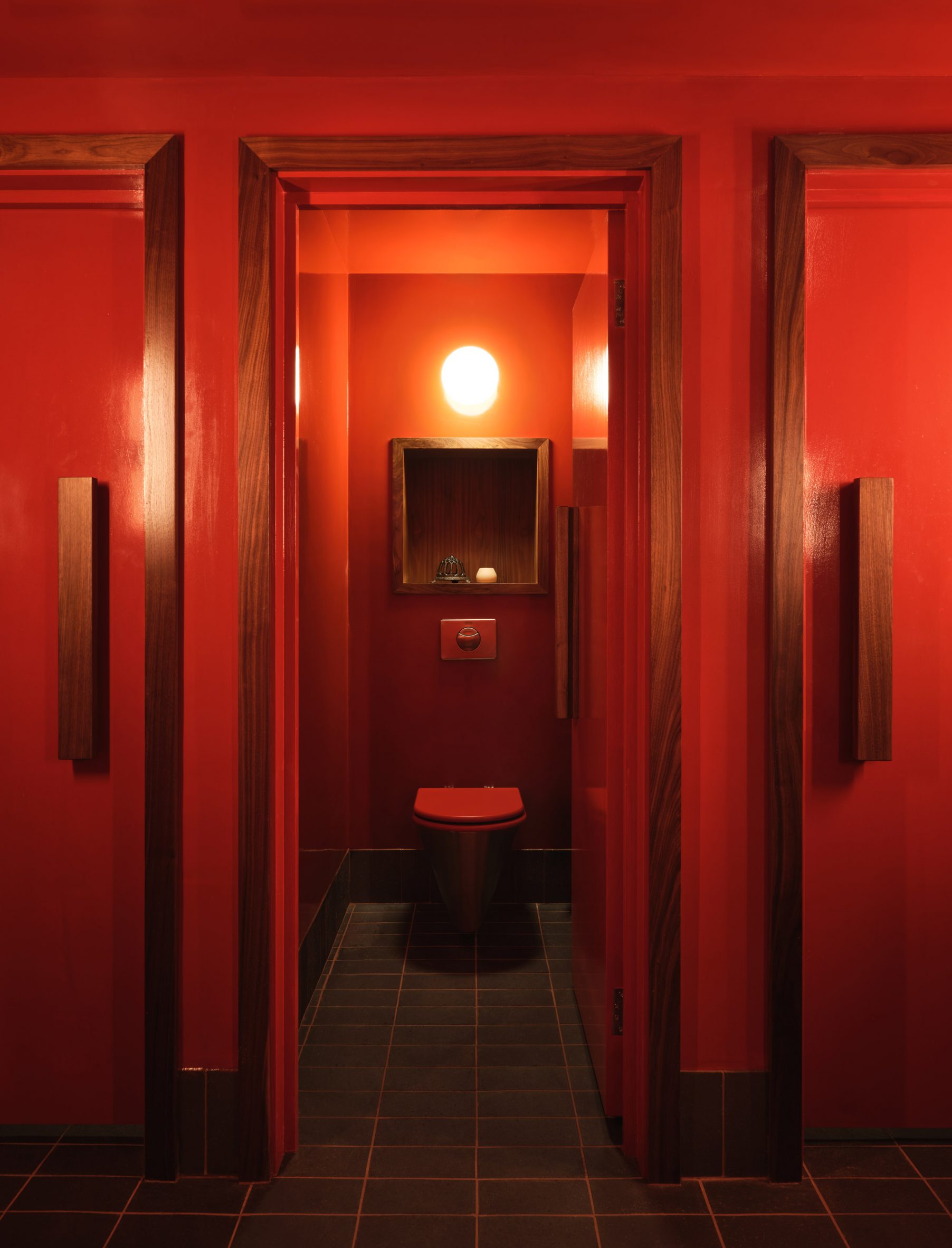 Interior view of the bright red toilet cubicles at SOMA Soho