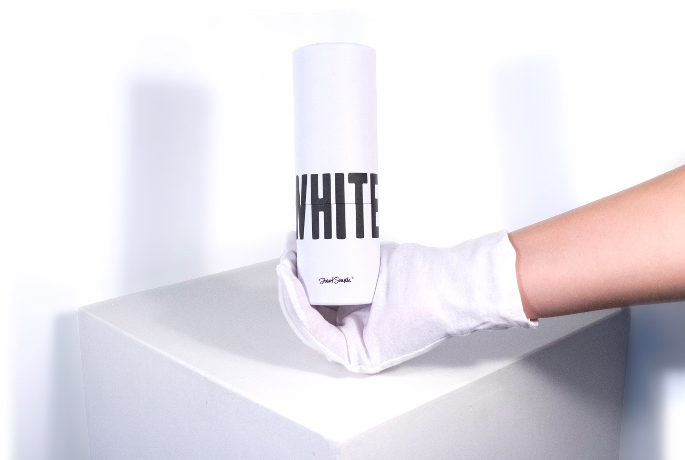 A hand holding White 2.0 in its packaging