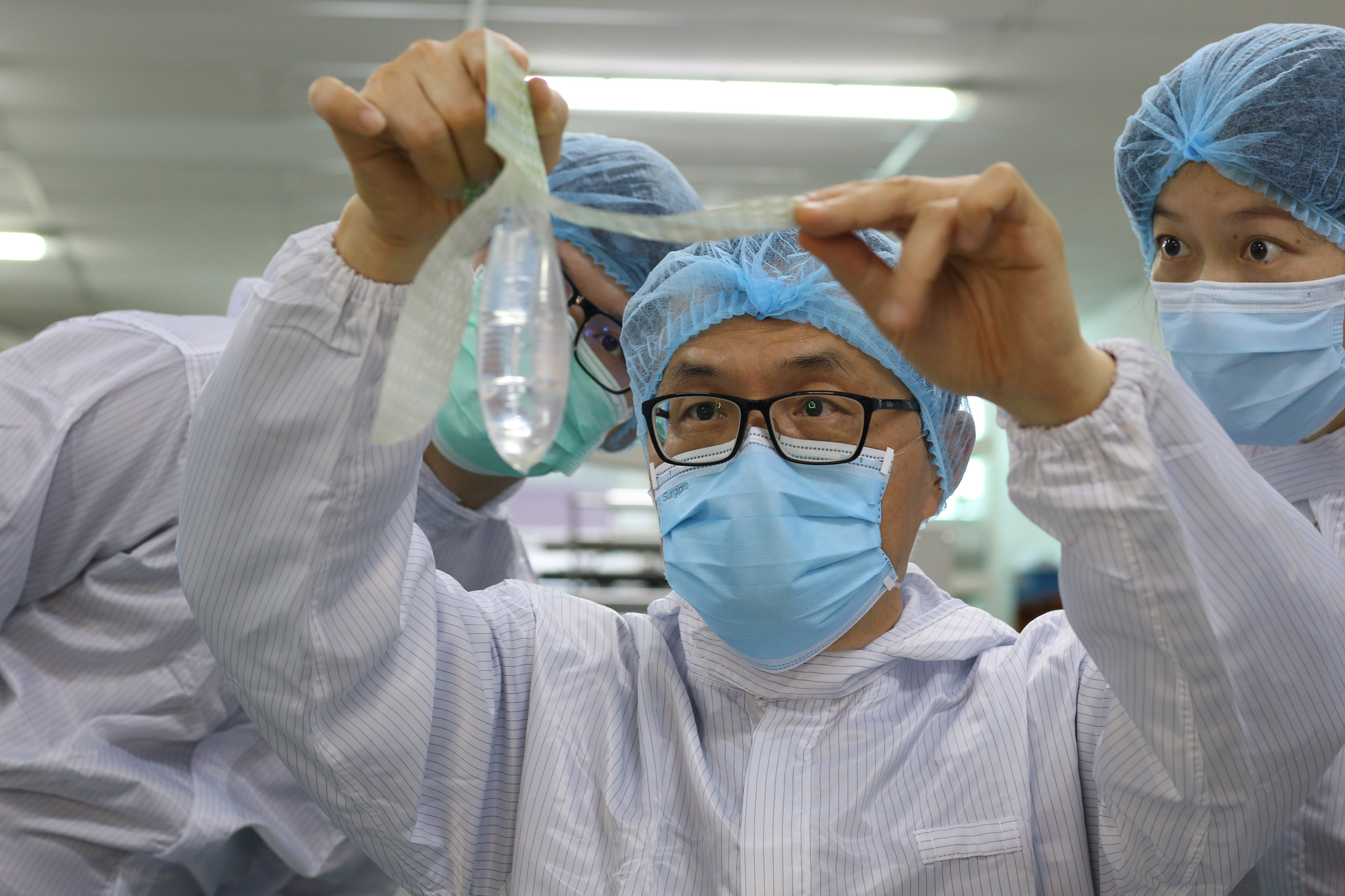 Doctors hold the Wondaleaf condom up for inspection