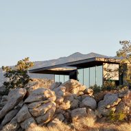 Boulders and pine trees surround High Desert Retreat by Aidlin Darling Design