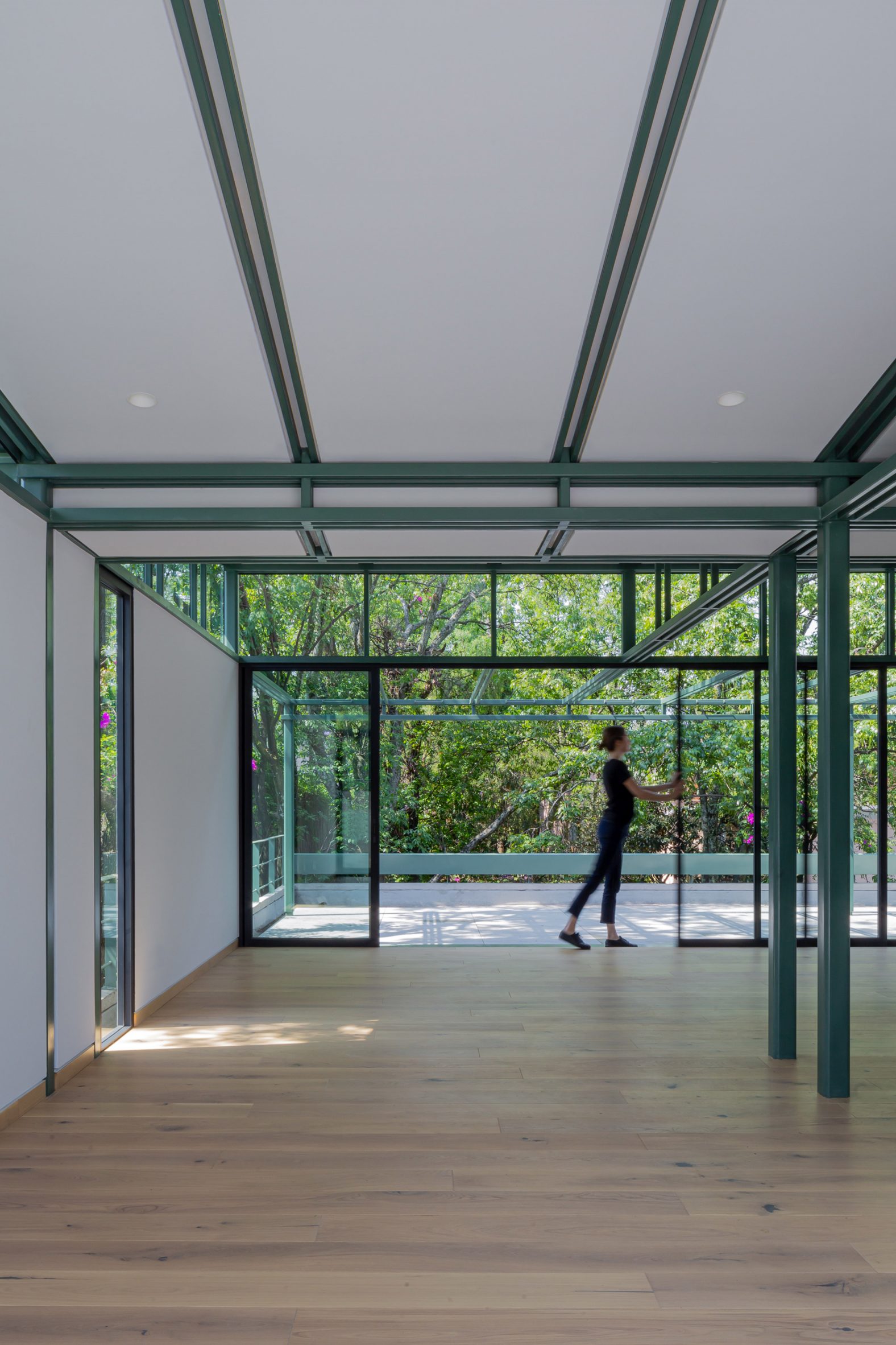 A woman inside an empty room with wooden floors